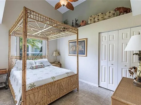 a bedroom with a large bed and a chandelier