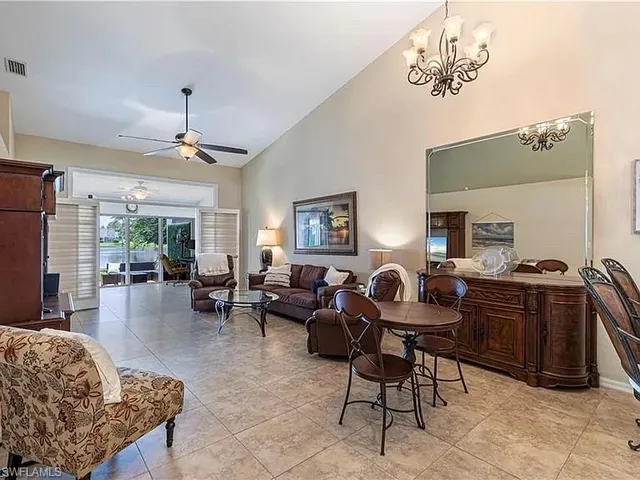 a living room with furniture a chandelier and a window