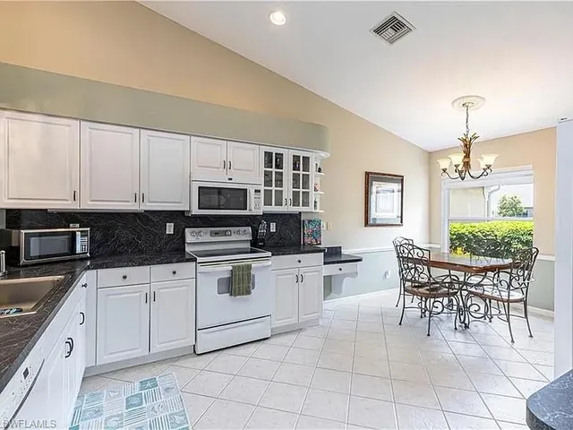 a kitchen with granite countertop cabinets and chairs