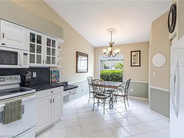 a kitchen with stainless steel appliances a dining table chairs and granite counter tops