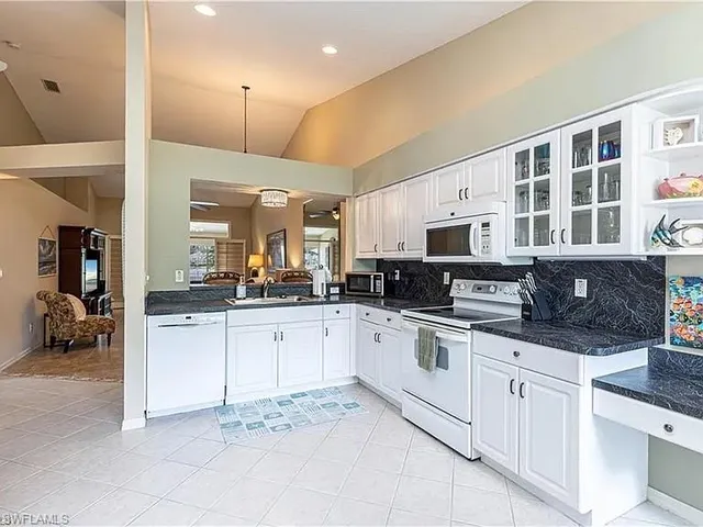 a kitchen with stainless steel appliances kitchen island granite countertop a sink and cabinets