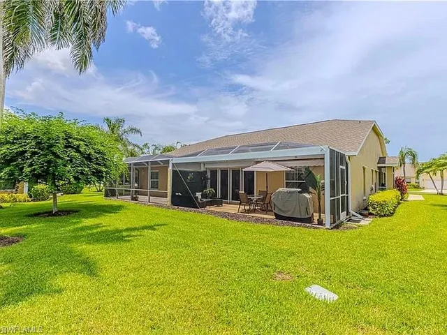 a view of a house with a big yard and large trees
