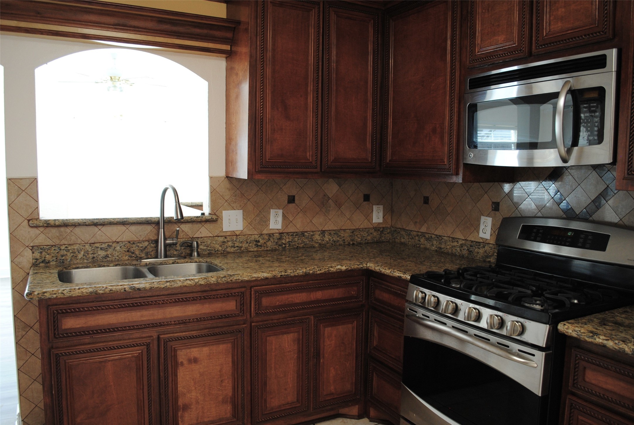 3910 Starbridge Pointe Lane Katy, TX 77449 - Photo 11 of 39 a kitchen with granite countertop a stove sink and microwave
