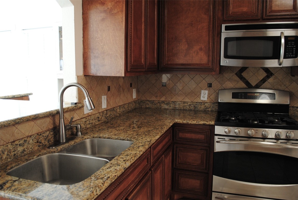 3910 Starbridge Pointe Lane Katy, TX 77449 - Photo 13 of 39 a kitchen with stainless steel appliances granite countertop a sink stove and microwave