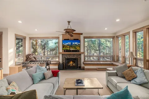 a living room with furniture fireplace and a large window