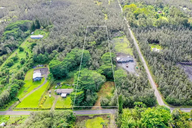 an aerial view of a residential houses with yard and swimming pool