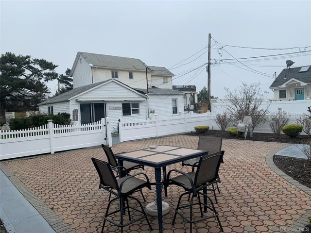 a view of a patio with table and chairs with wooden floor and fence