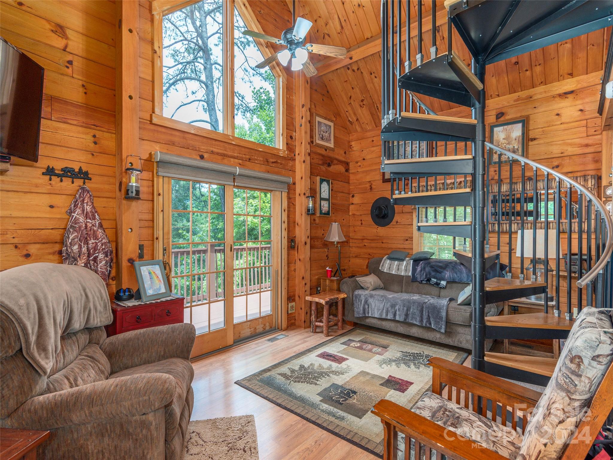 248 Skyview Road Whittier, NC 28789 - Photo 4 of 20 a living room with furniture a flat screen tv and a floor to ceiling window