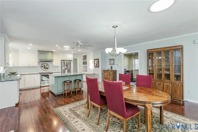 a kitchen with stainless steel appliances granite countertop sink stove refrigerator and dining table