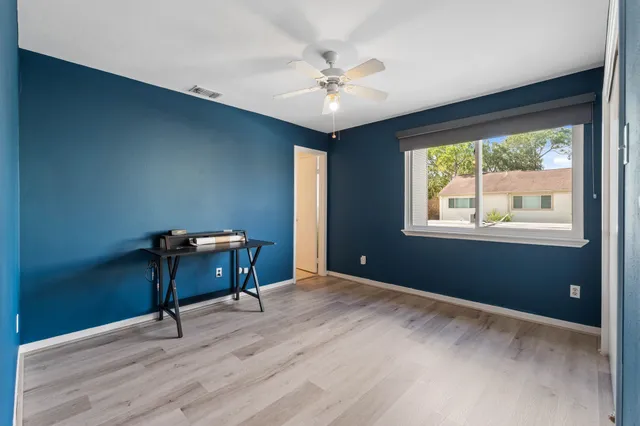 a workspace with wooden floor and windows