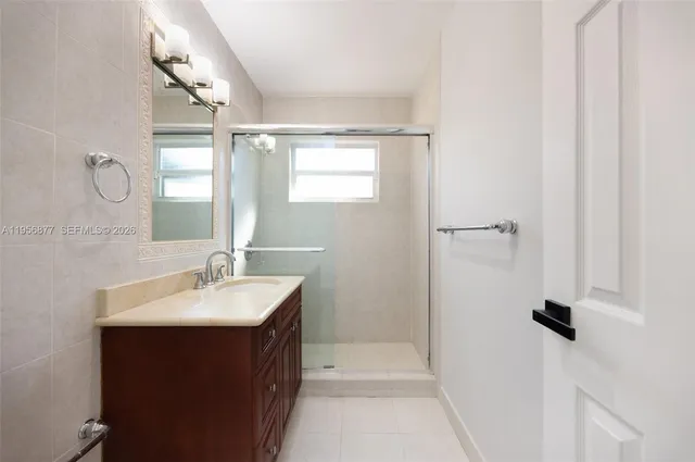a bathroom with a sink vanity granite and shower