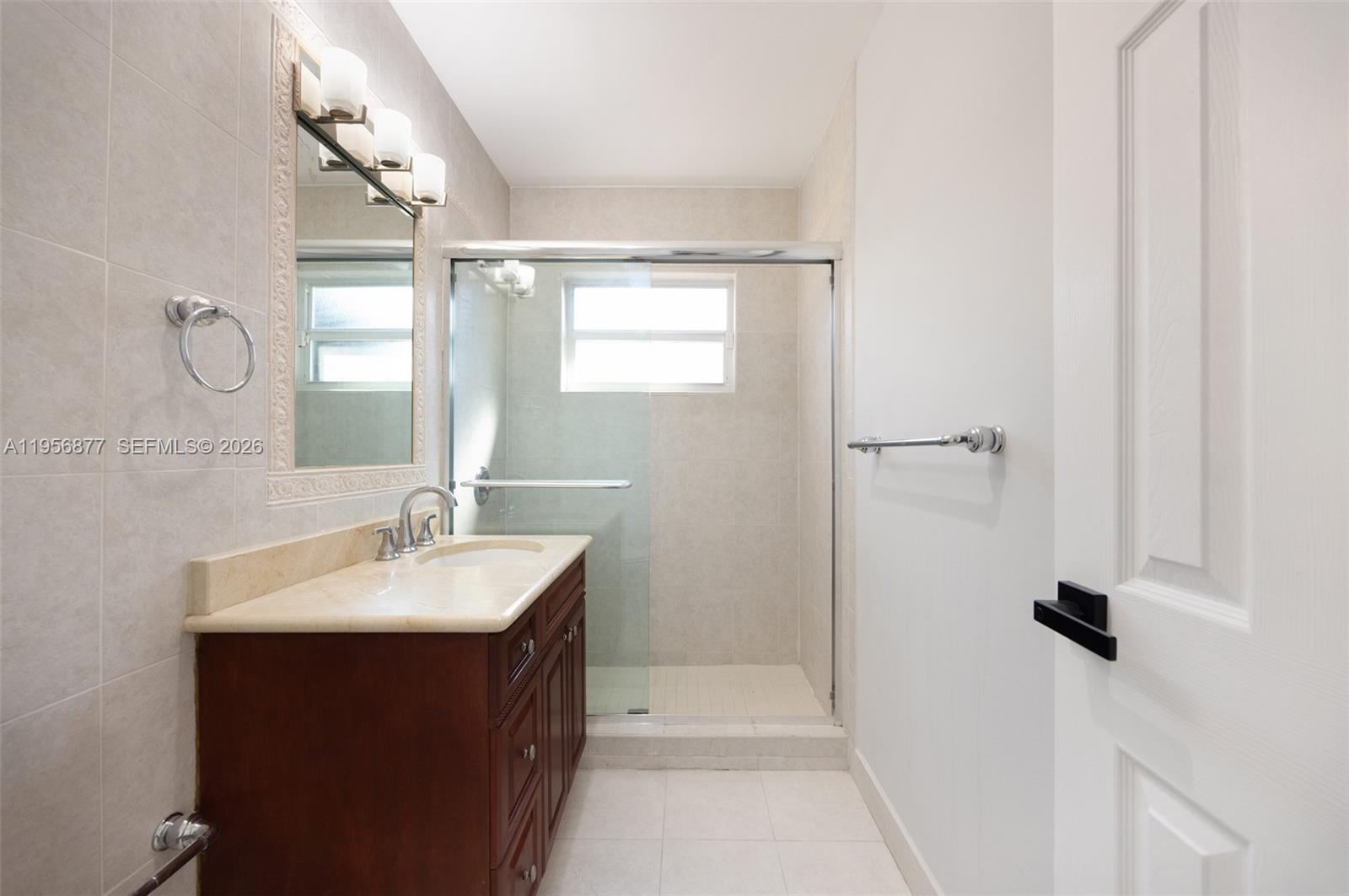 5730 Southwest 56th Terrace Miami, FL 33143 - Photo 13 of 18 a bathroom with a sink vanity granite and shower