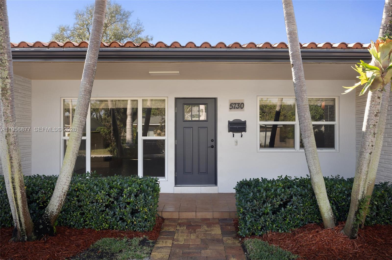5730 Southwest 56th Terrace Miami, FL 33143 - Photo 3 of 18 a front view of a house with a yard
