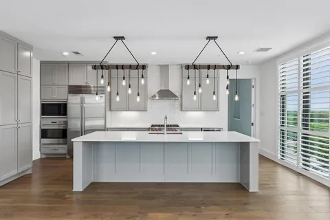 a kitchen with stainless steel appliances granite countertop a sink a refrigerator and cabinets