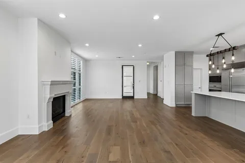 a view of a big room with wooden floor and a fireplace