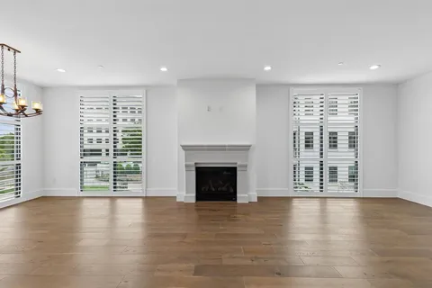 an empty room with windows and a fireplace
