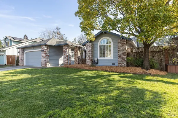 a front view of a house with yard and green space