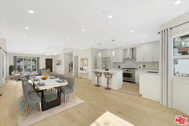 a open dining room with stainless steel appliances kitchen island granite countertop a table and chairs in it