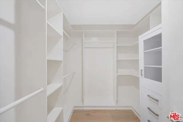 a view of walk in closet with empty racks