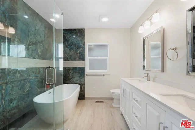a spacious bathroom with a bathtub shower sink mirror and toilet