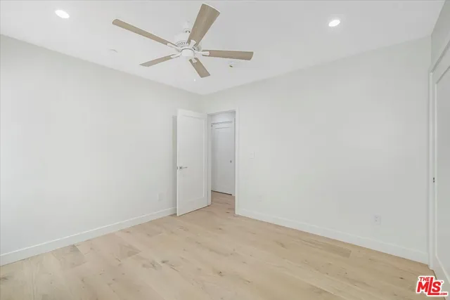 an empty room with a ceiling fan and a window
