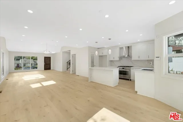 a open kitchen with white cabinets and white appliances