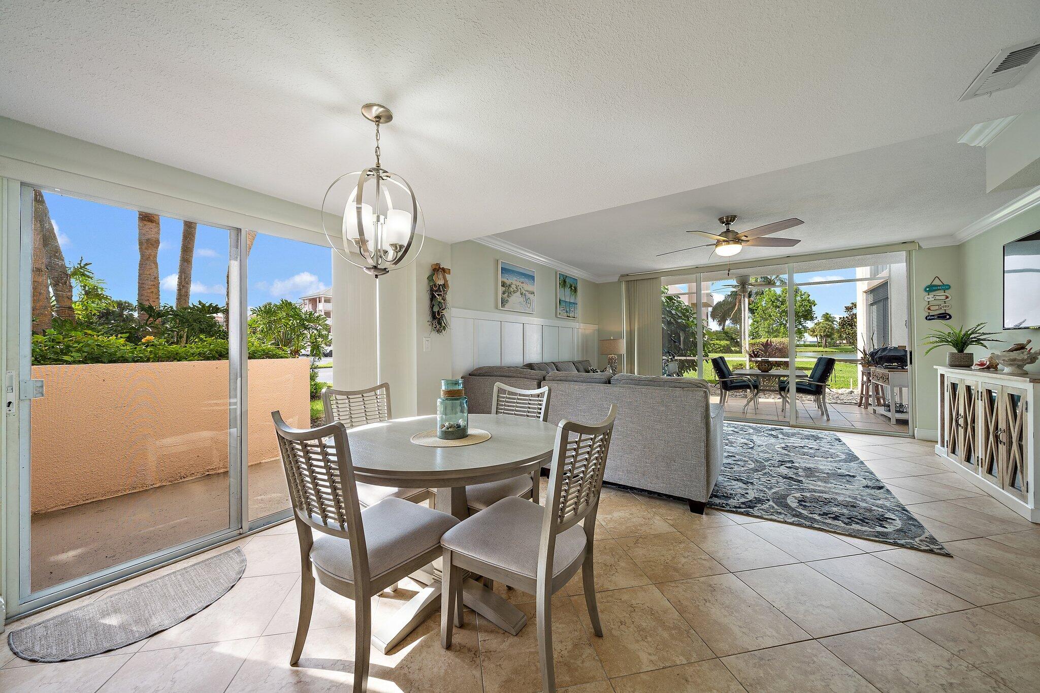 353 Highway 1, Unit D101 Jupiter, FL 33477 - Photo 11 of 32 a dining room with wooden floor a chandelier a wooden table and chairs