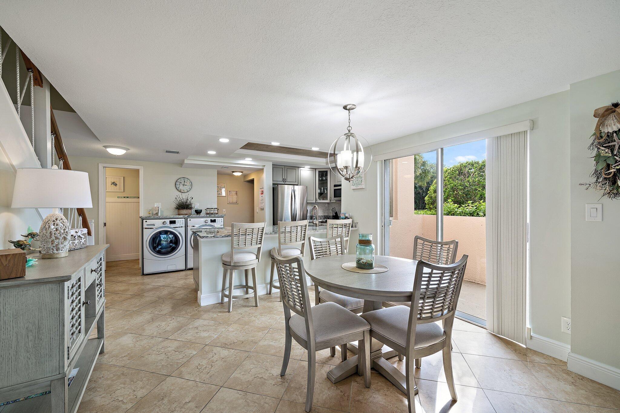 353 Highway 1, Unit D101 Jupiter, FL 33477 - Photo 12 of 32 a view of a dining room with furniture and chandelier