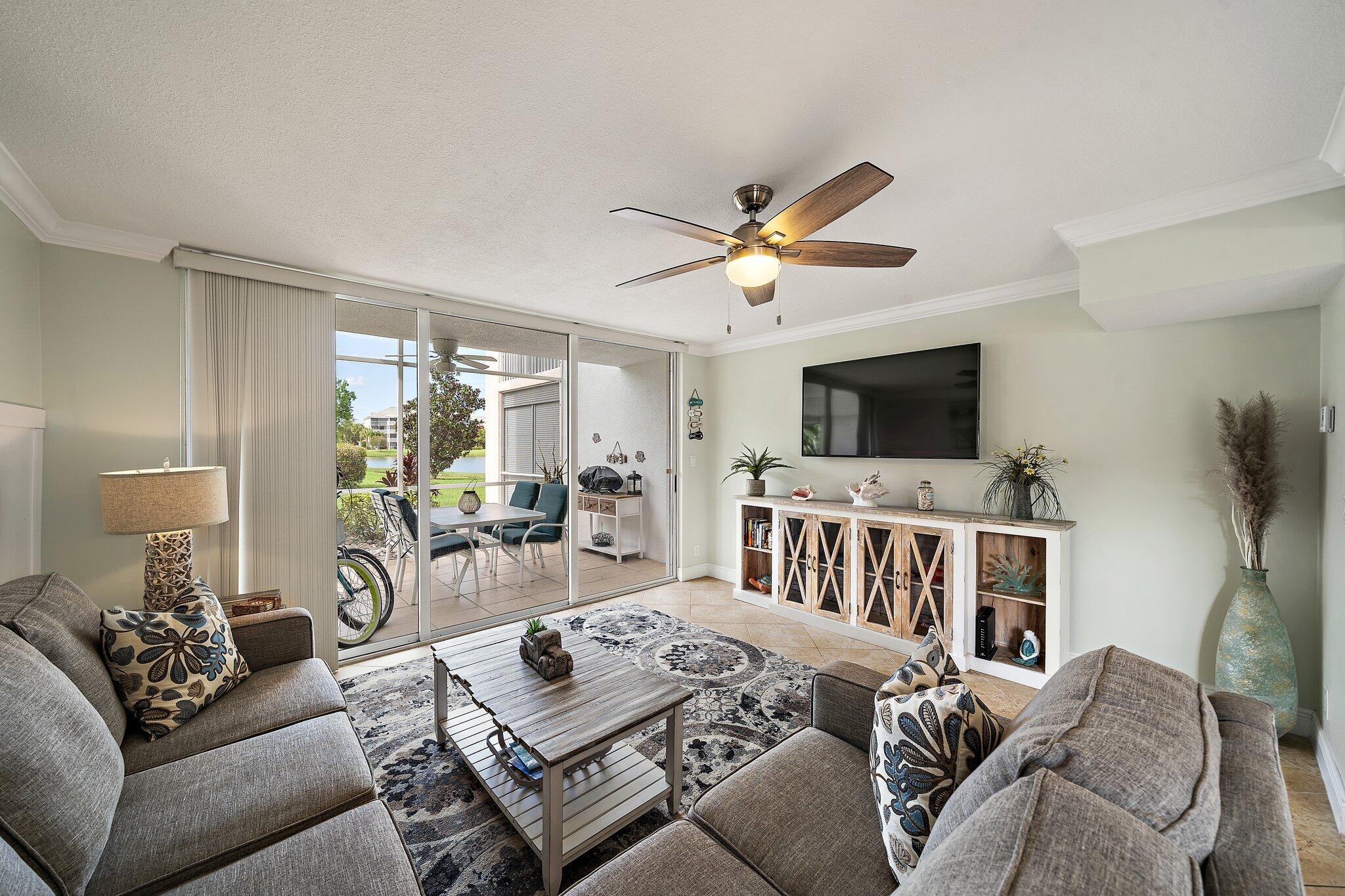353 Highway 1, Unit D101 Jupiter, FL 33477 - Photo 14 of 32 a living room with furniture a flat screen tv and a ceiling fan