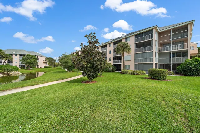 a view of a house with a big yard and potted plants