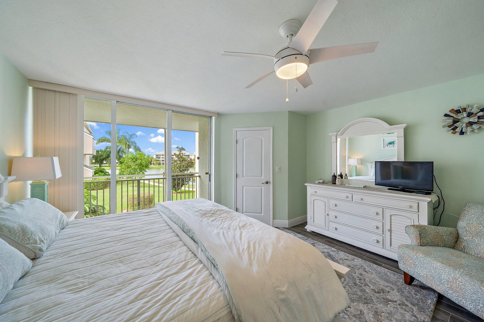 353 Highway 1, Unit D101 Jupiter, FL 33477 - Photo 23 of 32 a bedroom with a bed and a large window with a flat tv screen