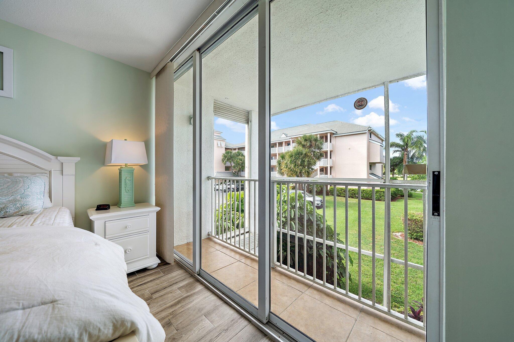353 Highway 1, Unit D101 Jupiter, FL 33477 - Photo 25 of 32 a bedroom with a large bed and a large window