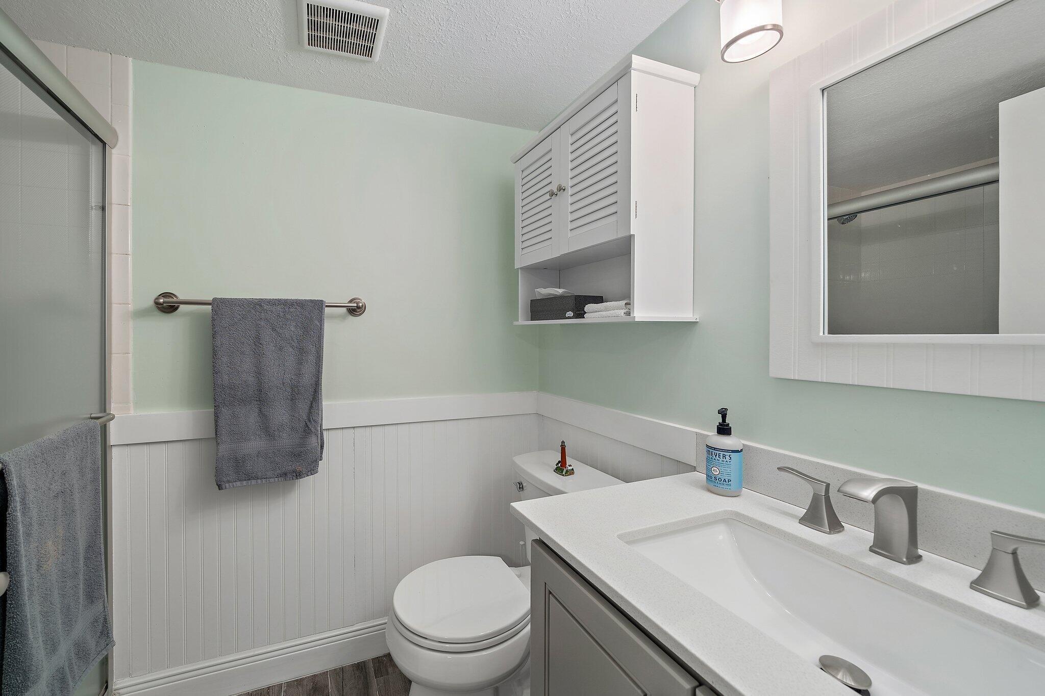 353 Highway 1, Unit D101 Jupiter, FL 33477 - Photo 26 of 32 a bathroom with a sink a toilet and mirror