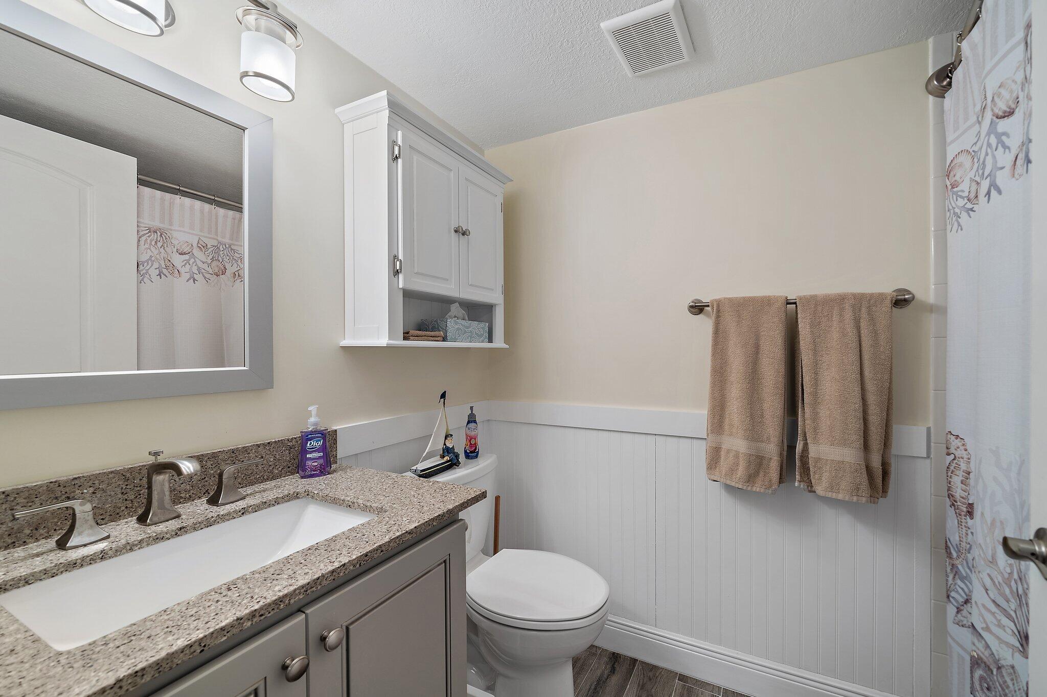 353 Highway 1, Unit D101 Jupiter, FL 33477 - Photo 29 of 32 a bathroom with a granite countertop toilet sink and mirror