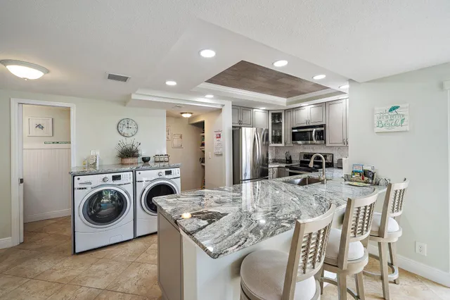 a kitchen with kitchen island a stove a table and chairs