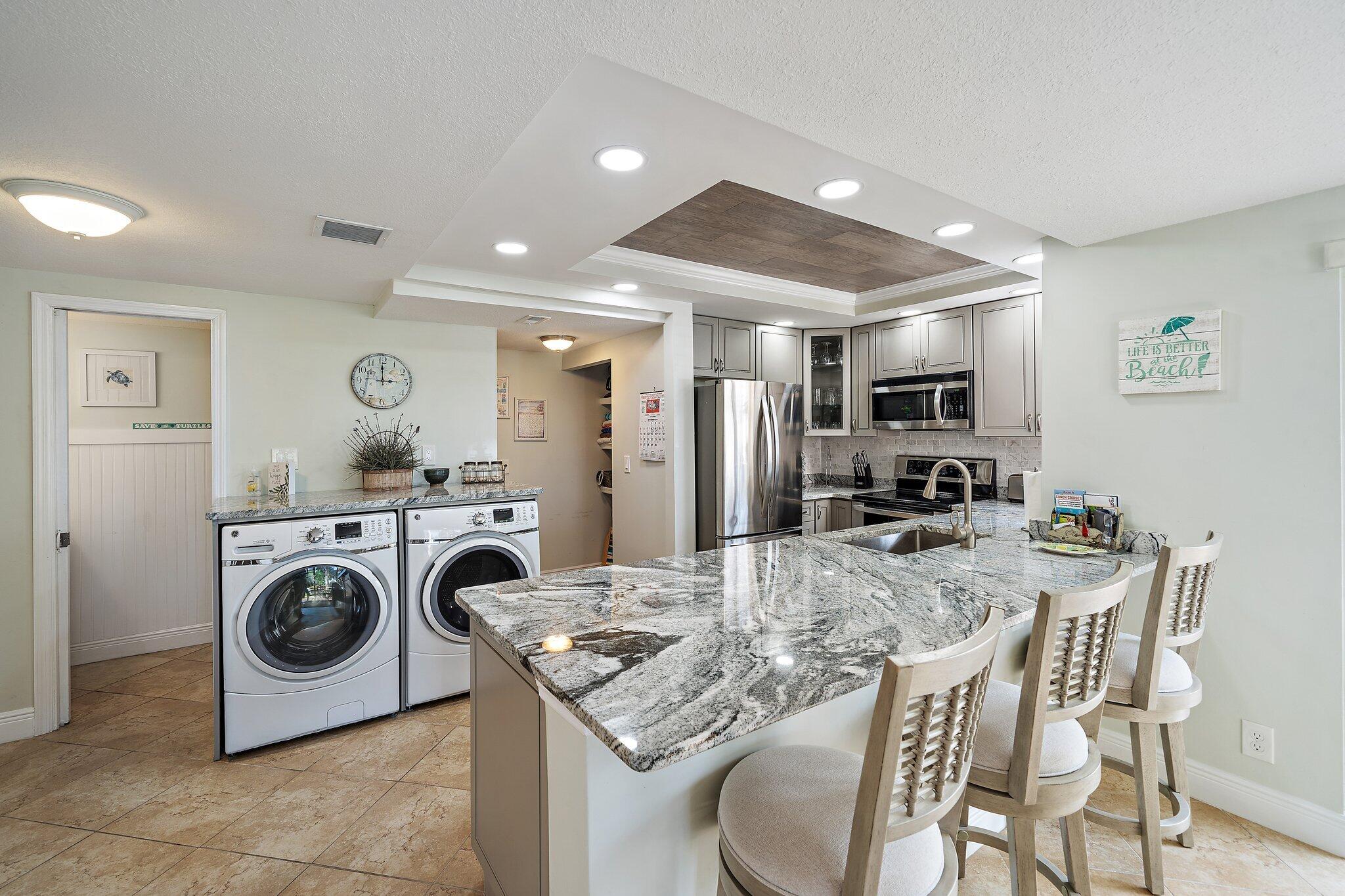 353 Highway 1, Unit D101 Jupiter, FL 33477 - Photo 6 of 32 a kitchen with kitchen island a stove a table and chairs