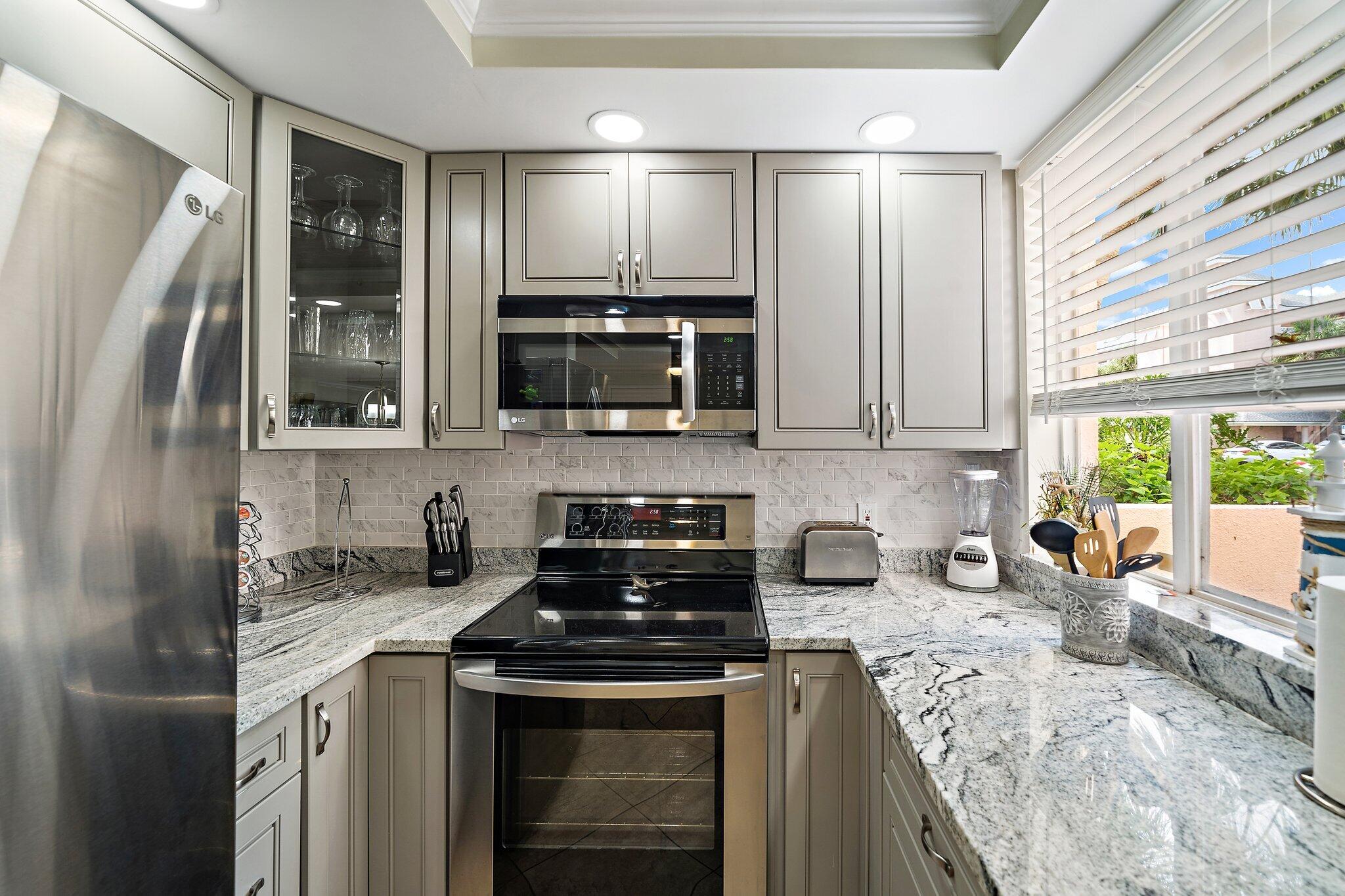 353 Highway 1, Unit D101 Jupiter, FL 33477 - Photo 8 of 32 a kitchen with stainless steel appliances granite countertop a sink stove and refrigerator