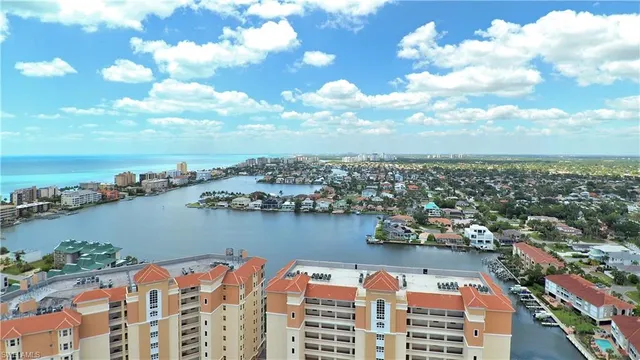an aerial view of ocean and residential houses with outdoor space