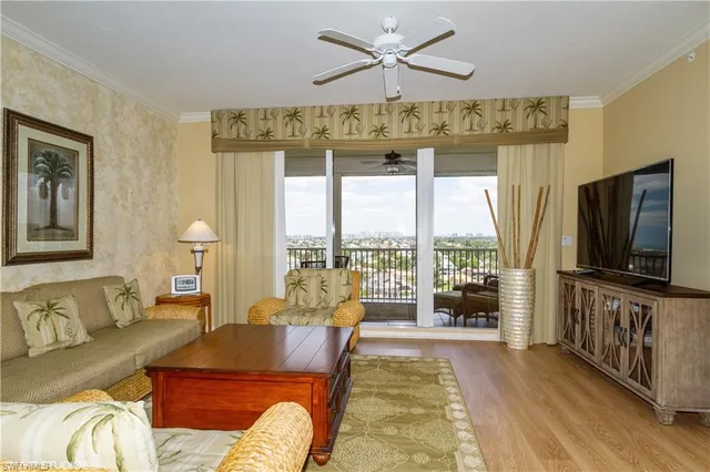 a living room with furniture tv and a floor to ceiling window