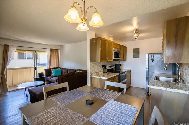 a living room with furniture a chandelier and a flat screen tv