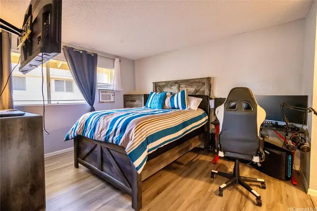 a bedroom with a bed and wooden floor