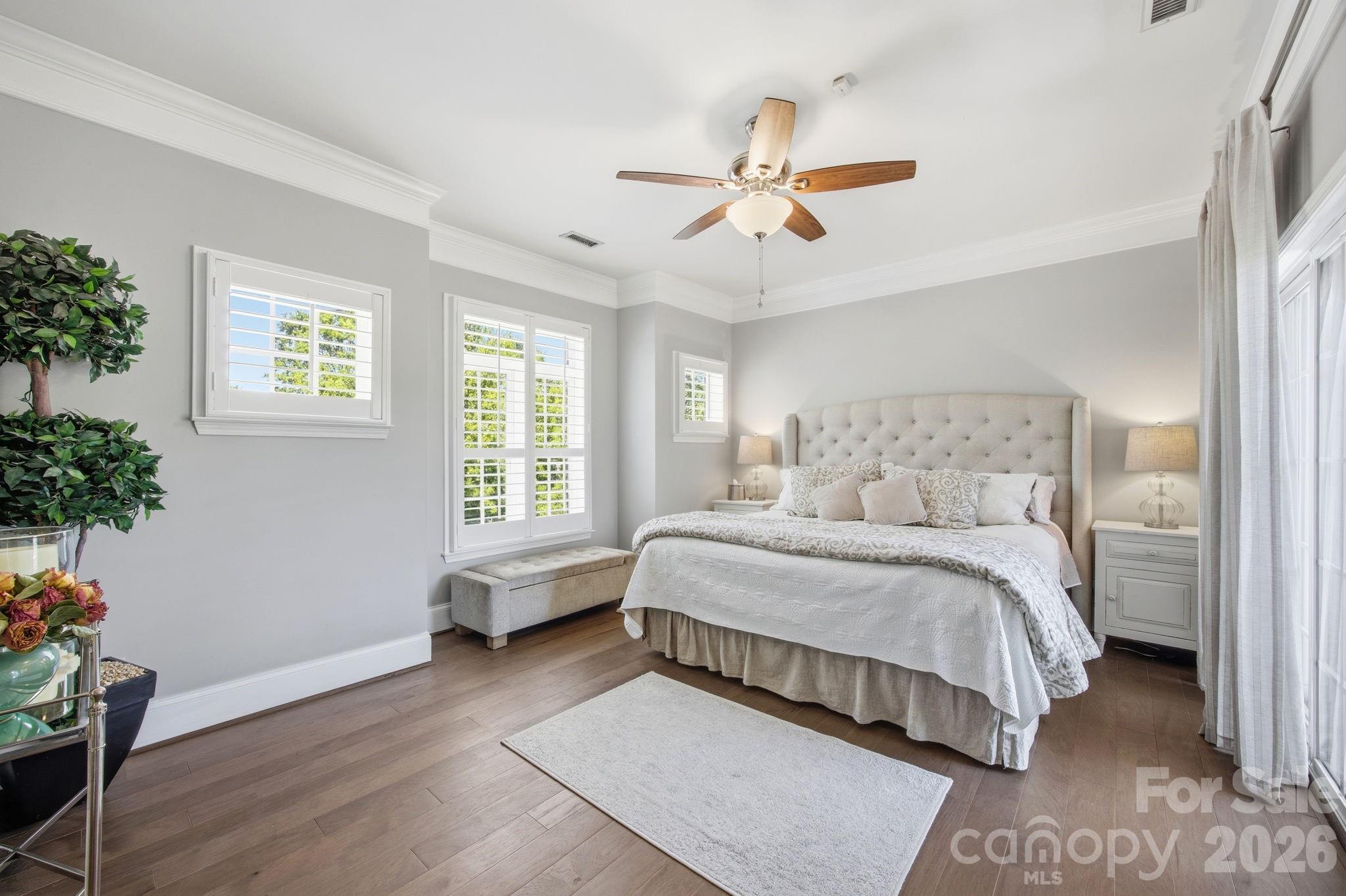 8942 Rosalyn Glen Road Cornelius, NC 28031 - Photo 19 of 47 a bedroom with a large bed and a chandelier