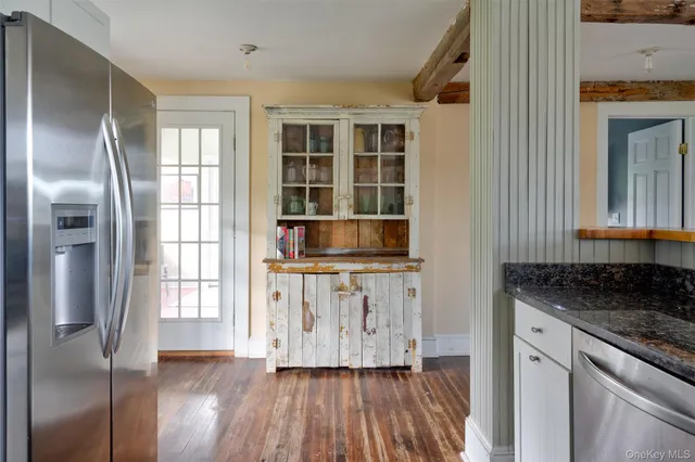 a kitchen with granite countertop white cabinets and wooden floor
