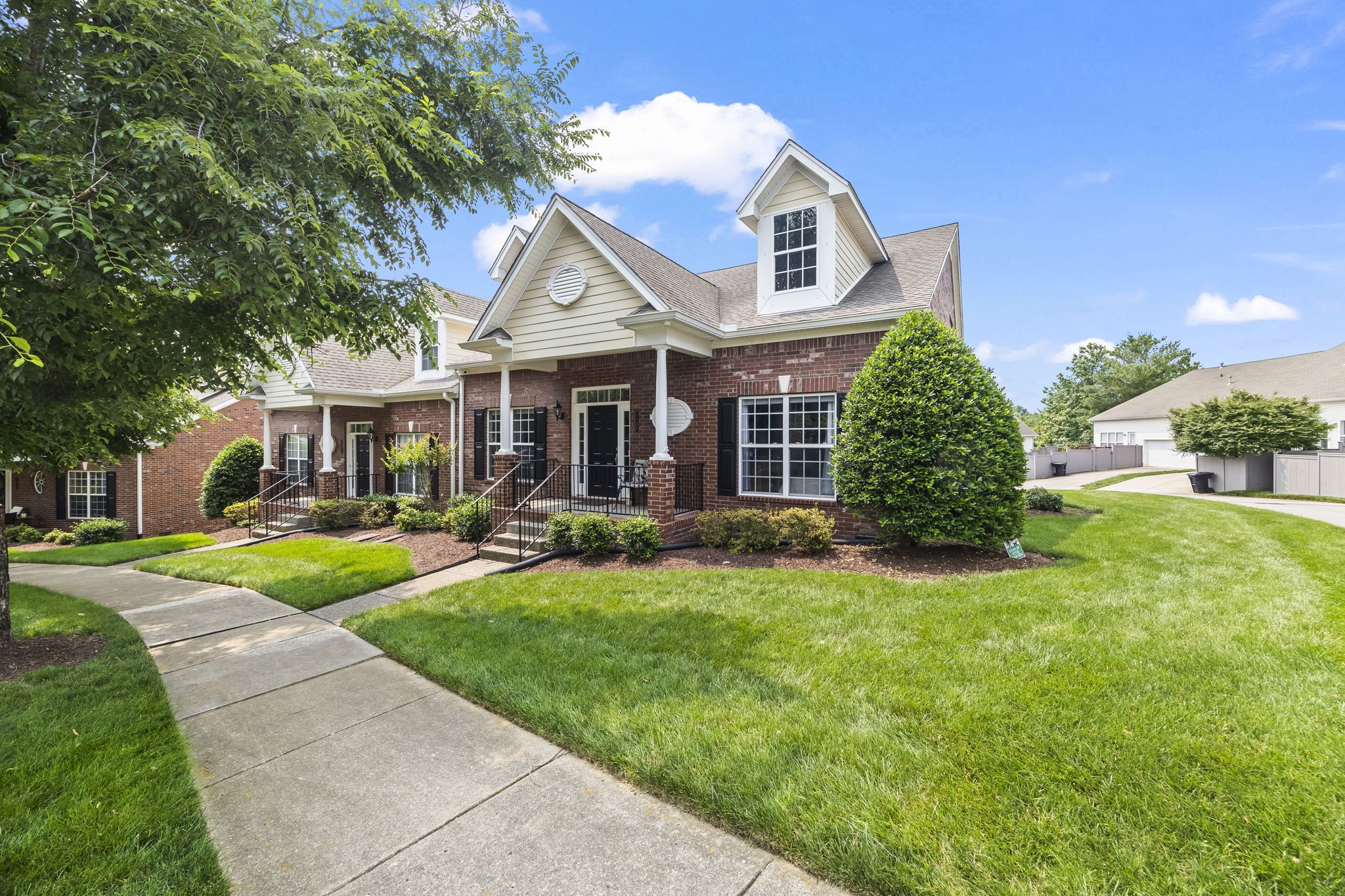 a front view of a house with yard and green space