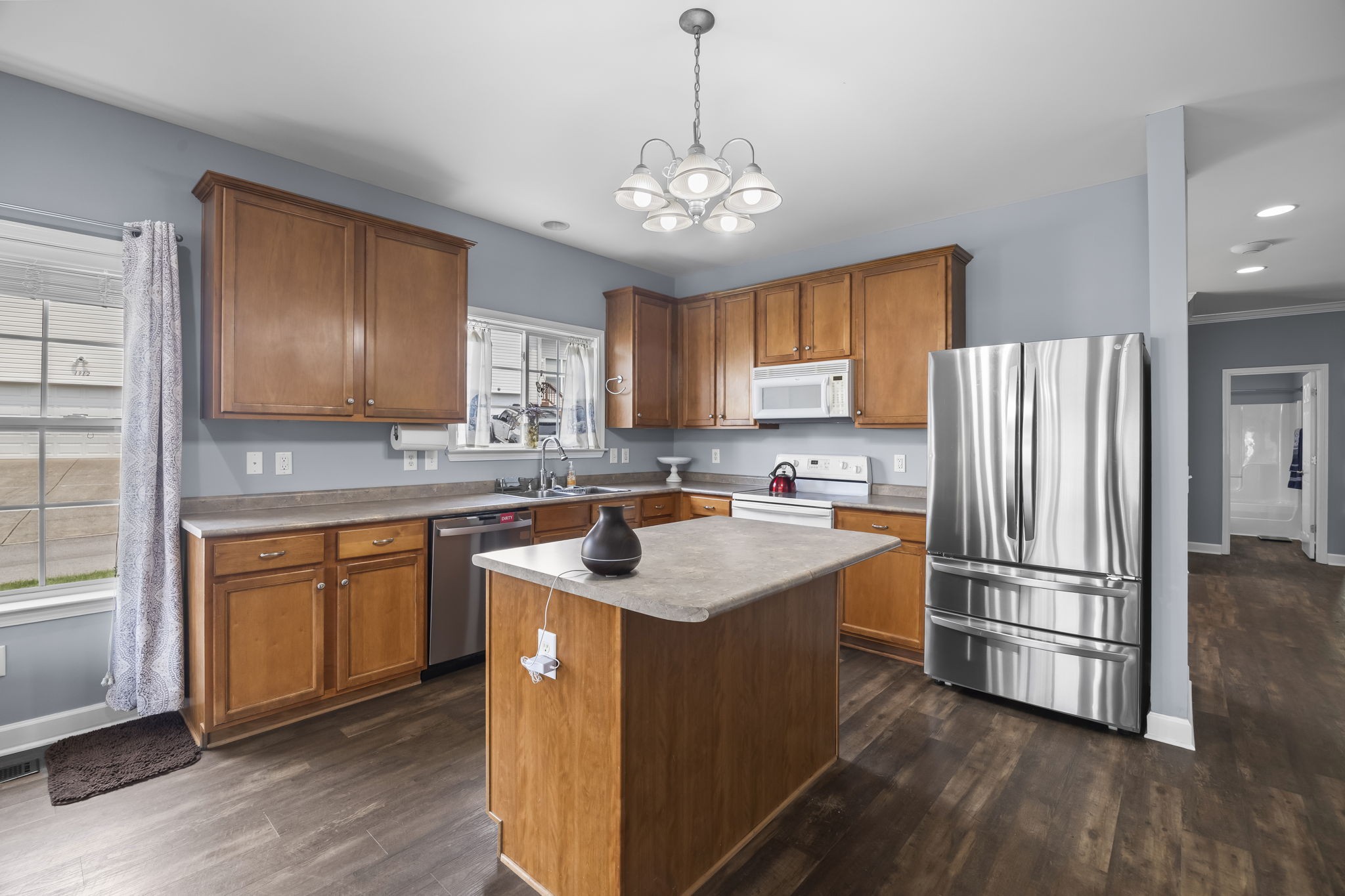 1305 Decatur Circle Franklin, TN 37067 - Photo 16 of 29 a kitchen with stainless steel appliances granite countertop a refrigerator a sink dishwasher a s stove top oven a large island with wooden floor and cabinets