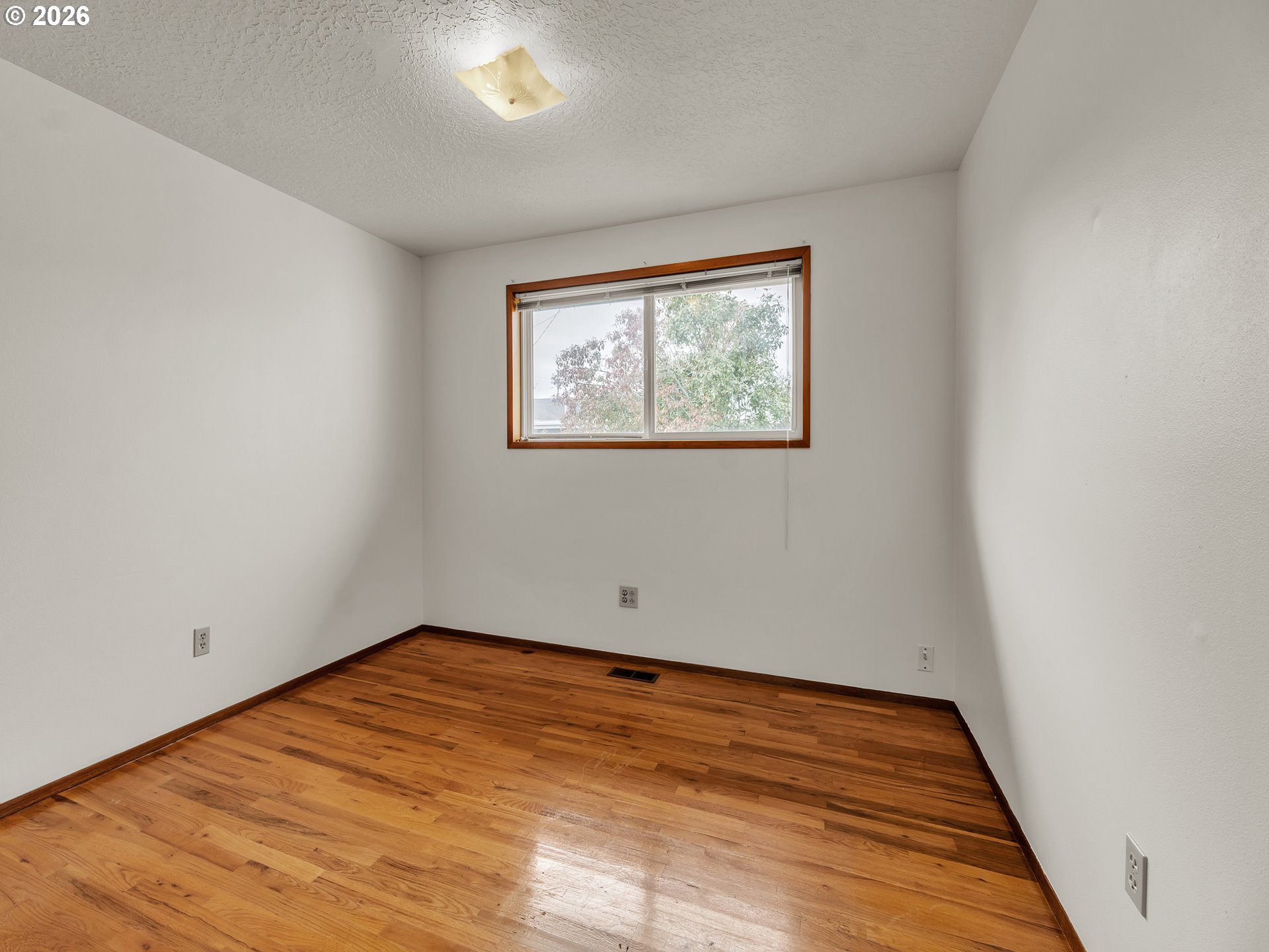 1749 Thompson Road Woodburn, OR 97071 - Photo 21 of 33 an empty room with wooden floor and window