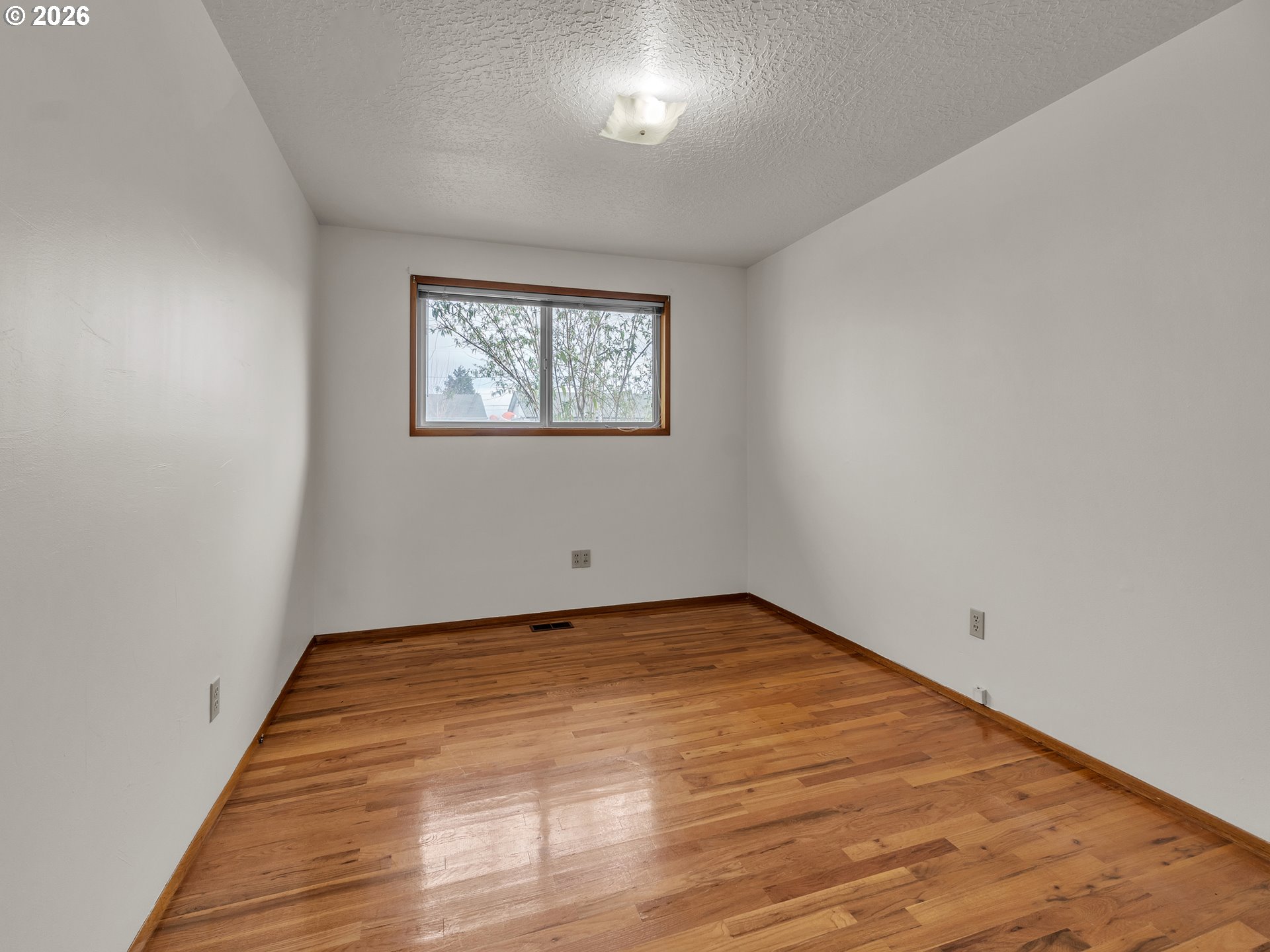 1749 Thompson Road Woodburn, OR 97071 - Photo 22 of 33 a view of an empty room with wooden floor