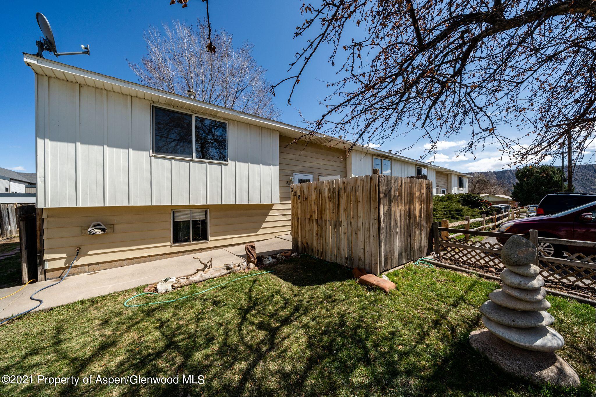 338 Ute Avenue Rifle, CO 81650 - Photo 1 of 14 a backyard of a house with a yard and potted plants