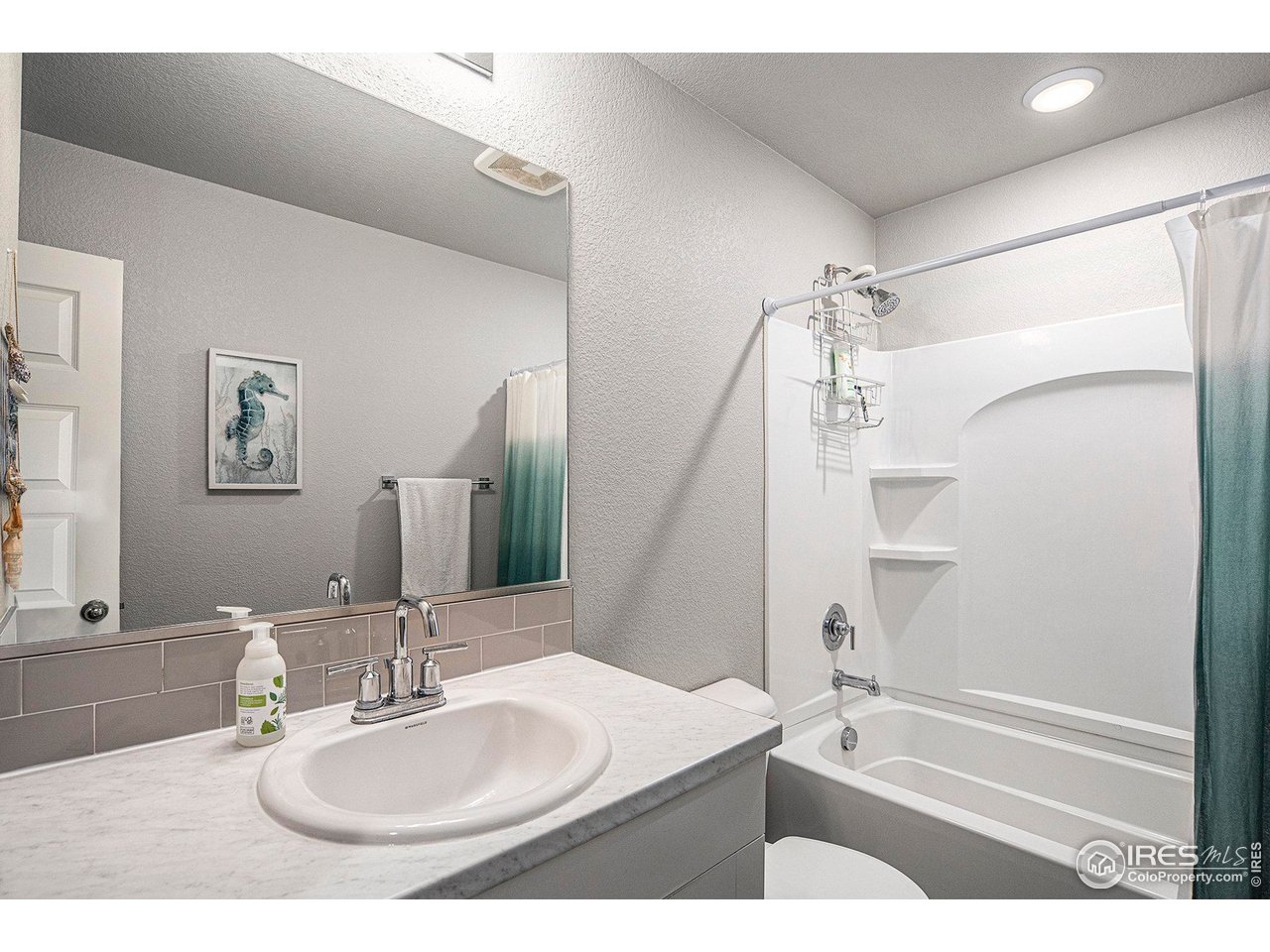 403 11th Avenue Wiggins, CO 80654 - Photo 11 of 13 a bathroom with a sink and a mirror