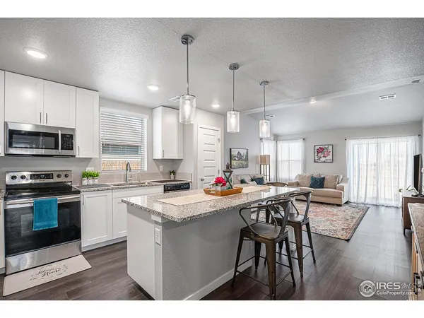 a kitchen with granite countertop a sink stainless steel appliances and counter space